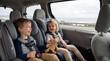 © Olesya - Happy boy and girl sitting in child car seat during family road trip. Children secured in vehicle restraint system for travel safety. Automotive transportation and parenting concept.