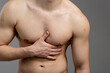 © skeronov - A young guy with an athletic build is experiencing painful sensations in the heart area. The concept of: heart disease, first aid, men's health