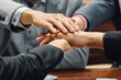 © kai - Diverse business professionals stacking hands together in unity, symbolizing teamwork, collaboration, and successful partnership in corporate environment.