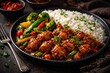 © The 2R Artificiality - Indian Chinese style Chicken Manchurian with basmati rice and mixed vegetables on dark backdrop