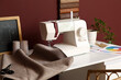 © Pixel-Shot - Sewing machine with fabric on tailor's table in atelier