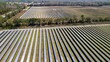 © AmazingAerialAgency - Aerial view of solar panels stretching across the landscape, reflecting the sky's hue, contrasting with the surrounding green fields, Elkton, Florida, United States.