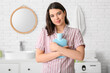 © Pixel-Shot - Young woman with hot water bottle in bathroom