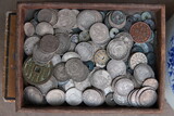 Fascinating collection of antique Chinese silver coins and various historical copper currency filling rustic wooden box, showcasing ancient numismatic treasures and cultural heritage
