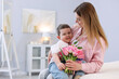 © New Africa - Little boy greeting his mom with flowers at home. Space for text
