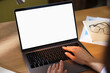© New Africa - Woman working with laptop at wooden table indoors, closeup