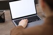 © New Africa - Woman working on laptop with blank screen at wooden table indoors, closeup