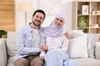 © New Africa - Happy muslim couple on sofa at home