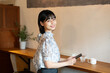 © amanaimages - カフェでスマホを持って笑っている女性