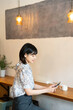 © amanaimages - カフェでスマホを見ている女性