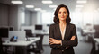© ErasTanveel - Confident Businesswoman in Office: A poised businesswoman stands confidently with arms crossed in a modern office, exuding professional presence and leadership.
