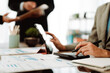 © Dino - Young colleagues discuss business and analytical price charts using calculators and laptops to calculate financial, tax, accounting, statistics and analytical research ideas.