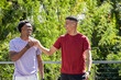 © Wavebreak Media - Diverse male friends fist bumping on terrace in front of foliage, with metal railing and bracelets