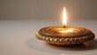 © Anna - Ornate gold brass diya lamp with glowing flame for diwali festival background, greeting card and poster design