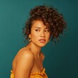 © Andrii Zastrozhnov - Female african young curly portrait teal background gold earrings strapless top warm tones glamorous pose