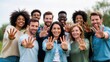 © Babb - Diverse group holding up hands outdoors in green park setting