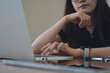 © tippapatt - Close-up of tired woman using laptop at home office, pensive remote worker in soft natural light.
