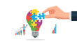 © Ripon - Large hand placing a blue puzzle piece into a colorful jigsaw light bulb symbolizing the completion of a creative idea or business strategy.