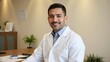 © Elena - A male physician in a white lab coat, smiling and holding a stethoscope, ready to examine patients.