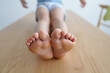 © designer rofiqul - Close up of childs bare feet resting on a wooden surface toes sole