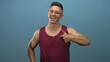 © Krakenimages.com - Man giving two thumbs up and smiling in studio blue backdrop with maroon tanktop and glasses; happiness positivity encouragement approval.