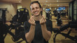 © Krakenimages.com - Man smiling and showing finger heart with hands in a studio gym setting, long hair visible and forearms bare; joy connection.