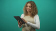 © Krakenimages.com - Woman in apron tapping tablet with right hand and holding device with left in studio, smiling while gesturing to screen; digital learning joy.