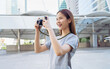 © sitthiphong - Young Asian woman traveler taking picture using a camera, summer tourism concept.