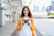 © sitthiphong - Young Asian woman traveler wearing orange shirt with taking picture using a camera at temple. summer tourism concept.