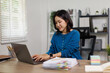 © David - Young Asian woman working remotely on laptop at a home office