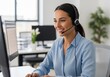 © Laurent - Professional Woman In Blue Shirt Wearing Headset Working On Computer In Modern Office Workspace