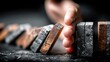 © asree - Domino effect falling, hand stopping dominoes, crisis management concept, business risk prevention, problem solving, close up
