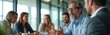 © Pete - Business people talk in meeting room. Diverse team discuss project strategy at table. Colleagues share ideas plan future work for corporate development.