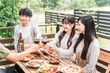 © buritora - A young Asian couple enjoys a home party/glamping on a wooden deck.
