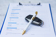 © vadish - Car insurance document with vehicle key and pen on clipboard. Concept of auto insurance policy, contract signing, vehicle protection, coverage and financial responsibility.