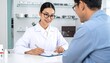 © Cornaldi - Eye doctor consult Asian woman in lab coat consults patient on eyewear. Soft lighting & white table