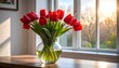 © Lepet - A vibrant bouquet of red tulips rests in a clear vase on a wooden surface, bathed in sunlight from a nearby window. The warm light illuminates the scene