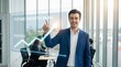 © PicAura - A confident businessman presenting a future growth plan in a modern office setting with a team in the background.