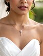 © lesung - Portrait of a person in a white strapless dress. A gold necklace with flower pendant and earrings. The background is blurred