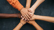 © HADI INCREDIBLE - Diverse group of people stacking hands in a circle, showing unity and teamwork on a dark background.
