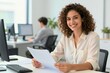 © SnapScape - Young Woman With Curly Hair Smiling Directly Towards Camera In Office Setting Cheerful Confident Ethnicity Middle Eastern Judging By Facial As Almond Shaped