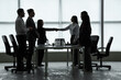 © Pixel-Shot - Silhouettes of business people shaking hands at table in office