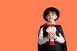 © Pixel-Shot - Little magician with playing cards on orange background
