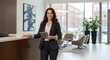 © Wattana - A woman in a professional setting, standing in front of a reception desk with a tablet.