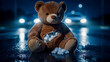© NOVÁKOVÁ KATEŘINA - A deeply forlorn and worn brown teddy bear, its chest tragically torn open revealing soft white stuffing, sits abandoned alone on a dark, wet street at night, illuminated by the distant, blurred...