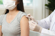 © Pormezz - People getting a vaccination to prevent pandemic concept. Woman in medical face mask  receiving a dose of immunization coronavirus vaccine from a nurse at the medical center hospital