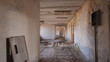 © bisonov - Long Peeling Corridor In Exclusion Zone, Cracked Plaster Walls, Scattered Rubble And Exposed Wiring, Dim
