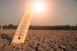 © r_tee - Scorching sunlight over arid land with a thermometer indicating dangerous heat levels and climate crisis.