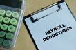 © syahrir - Concept of payroll deductions write on clipboard isolated on Wooden Table. For financial planning, tax calculation and salary management