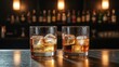 © mila103 - Two whisky glasses with ice placed on polished bar